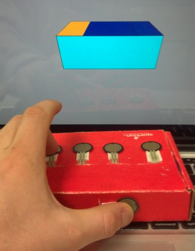 The final device inside a cardboard box. Shown in back is the real time force display software. Blue correlates to no pressure, while warmer colors refer to higher pressure.