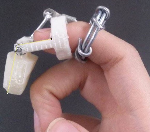 Final Design: a 3D-printed prosthetic finger with mechanical elements. These mechanical elements replace the elements that would be too small or fragile to 3D print.