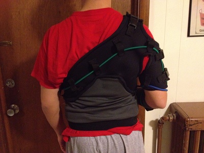 Back view of the sling including vest components, bands, belt loop holes, and elastic band at bottom of torso.