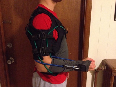 Side view of the sling includes shoulder strap, arm sleeve, bands, attachment points, belt loop holes, and forward facing adjustable arm bands.