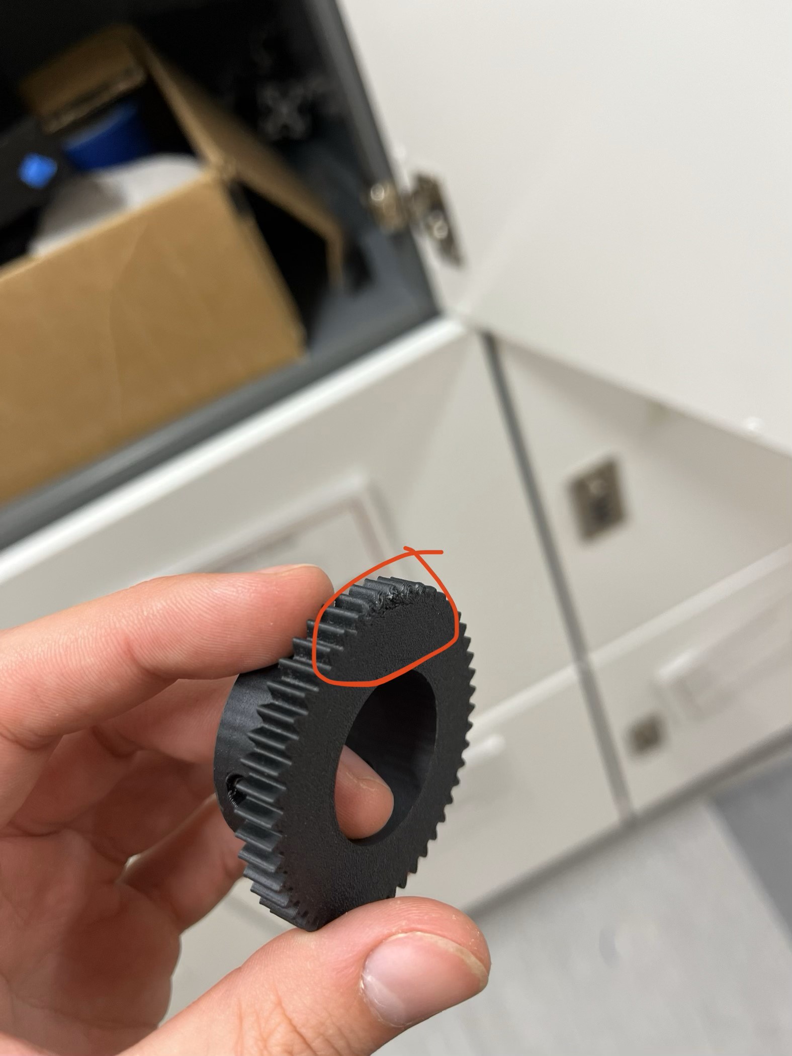 A control knob gear that was damaged after an attempt to insert heated threads into the plastic