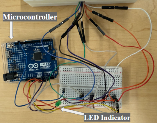 Microcontroller and breadboard with circuit including LED output and four sensor inputs